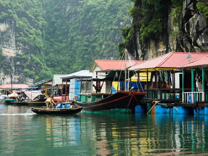 Làng Ngọc Tùng Sâu với các thuyền và các dãy núi đá vôi ở Vịnh Hạ Long phía sau.