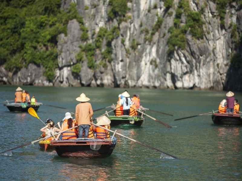 Chuyến đi thuyền tre qua Hang Luồn tại Vịnh Hạ Long, với các vách đá vôi hùng vĩ và làn nước yên ả.